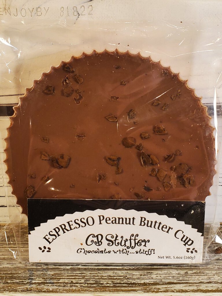 A peanut butter cup with visible espresso bean pieces embedded in the chocolate.