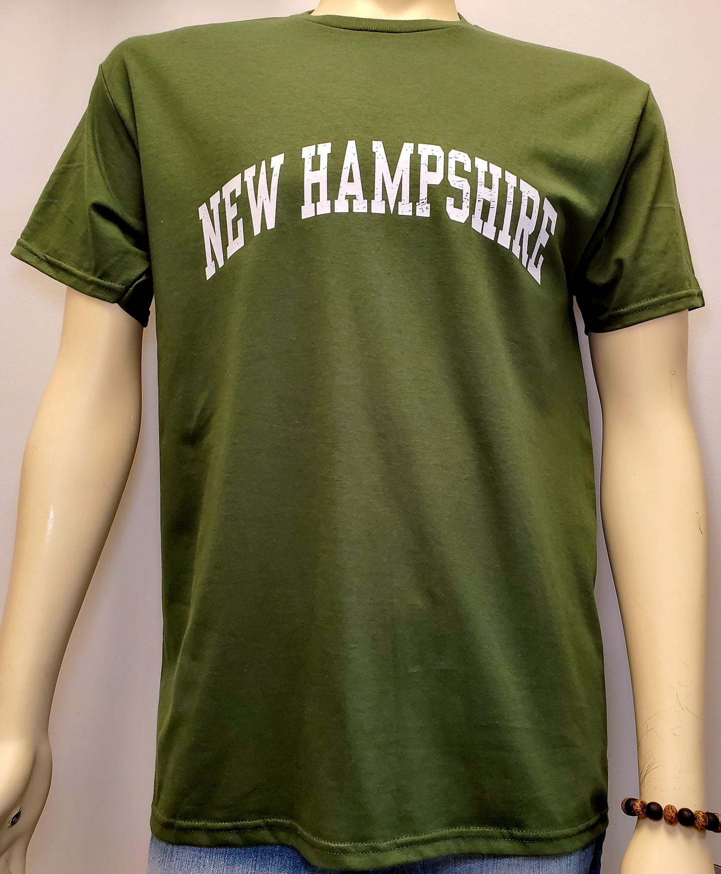 Green t-shirt with 'NEW HAMPSHIRE' text on a mannequin against a plain background