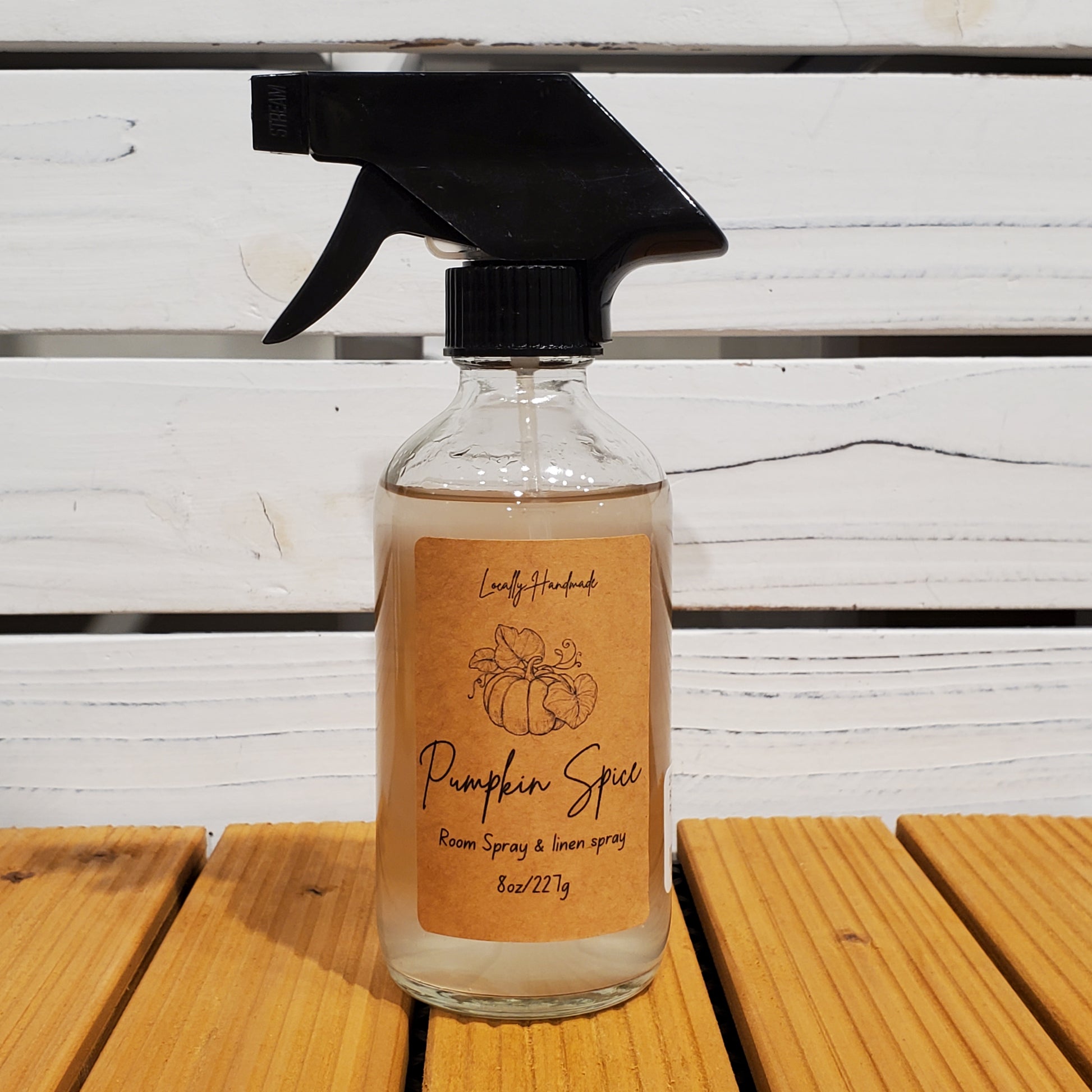 Pumpkin spice spray bottle on a wooden surface