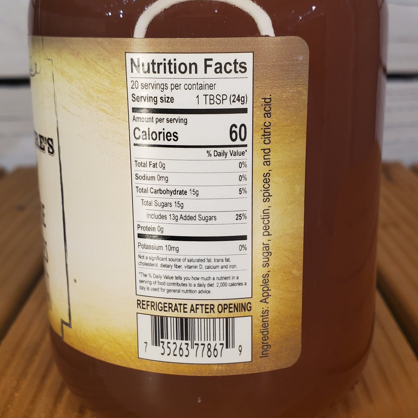 Close-up of a nutrition facts label on a bottle with a wooden surface in the background.