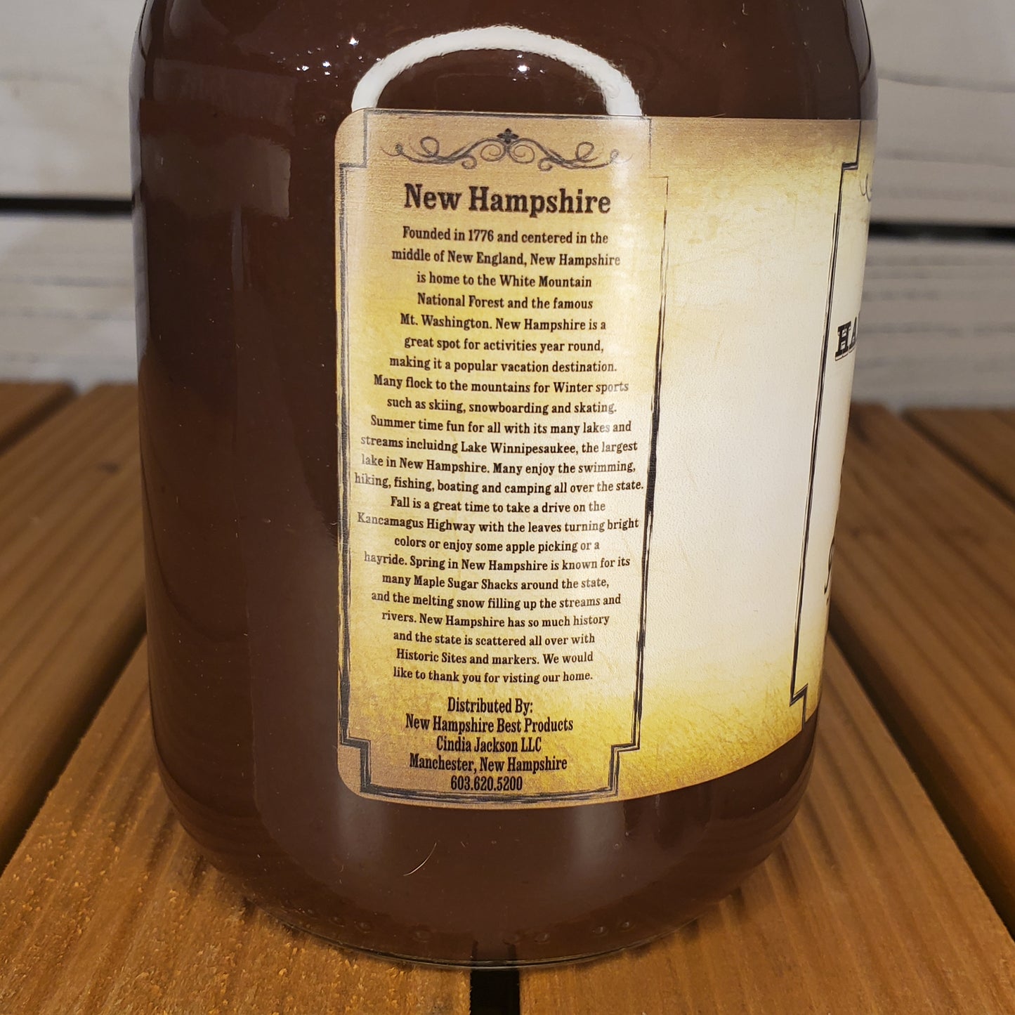 Bottle of New Hampshire maple syrup with a label on a wooden surface