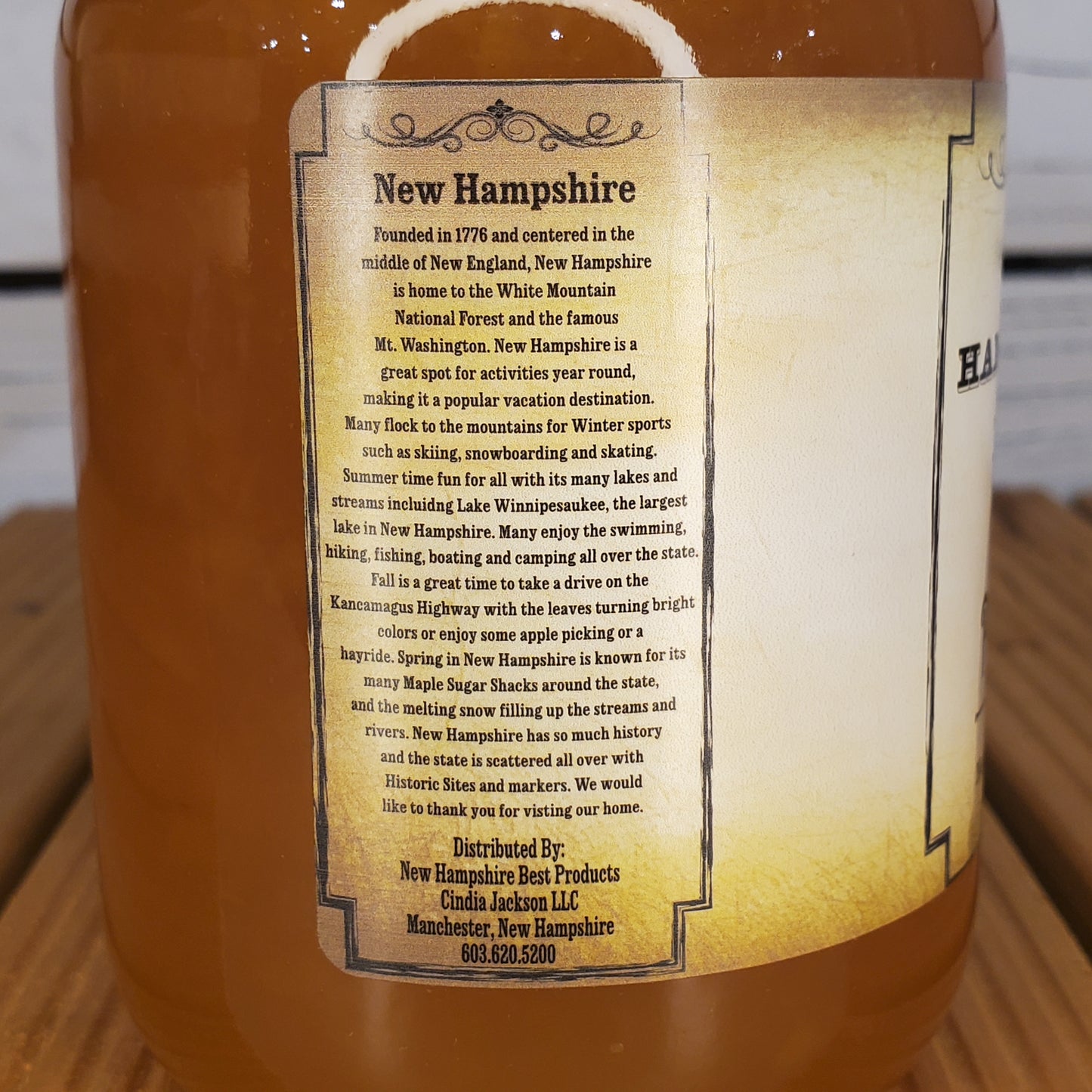 Bottle label with text about New Hampshire on a wooden surface