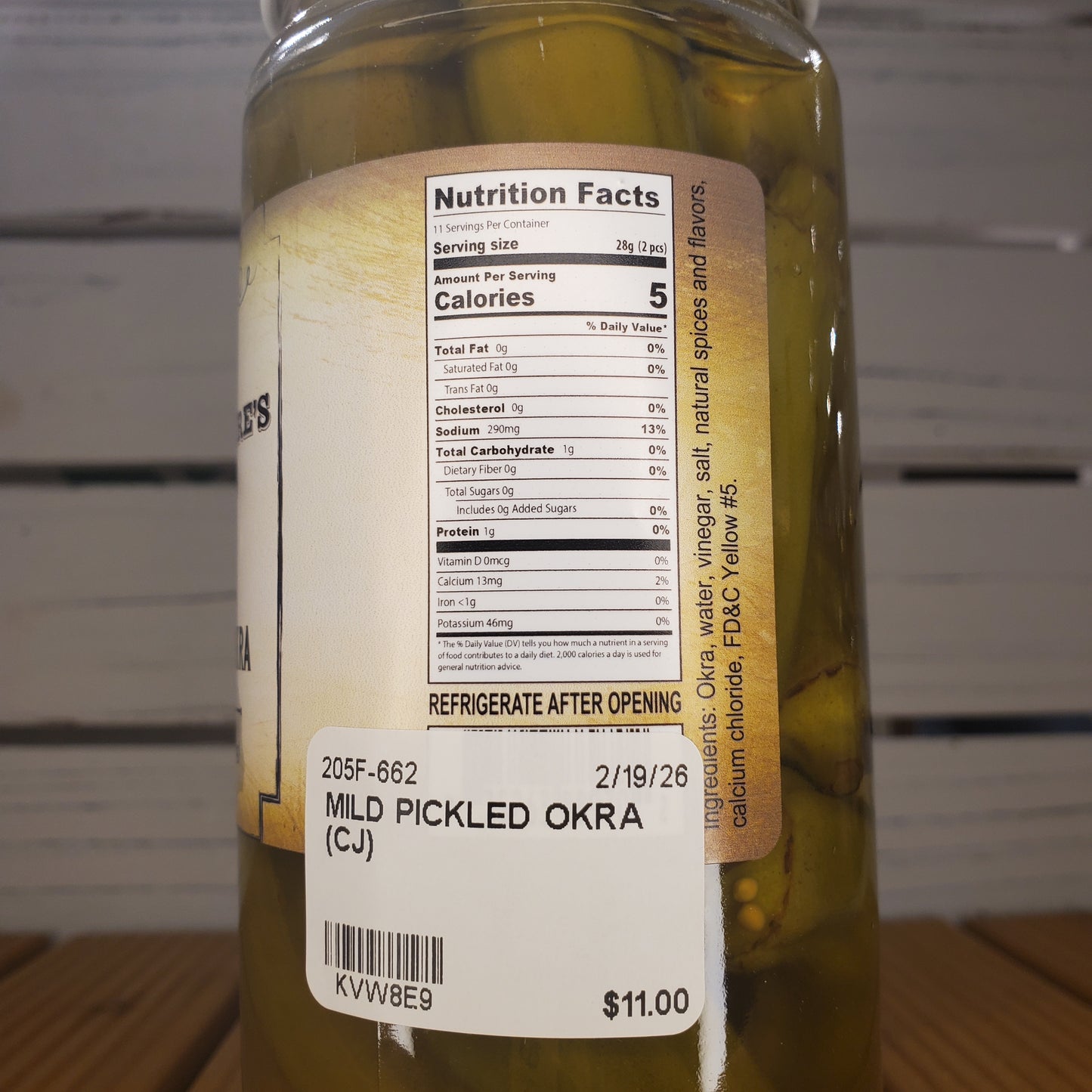 Jar of pickled okra with nutrition label on a wooden surface