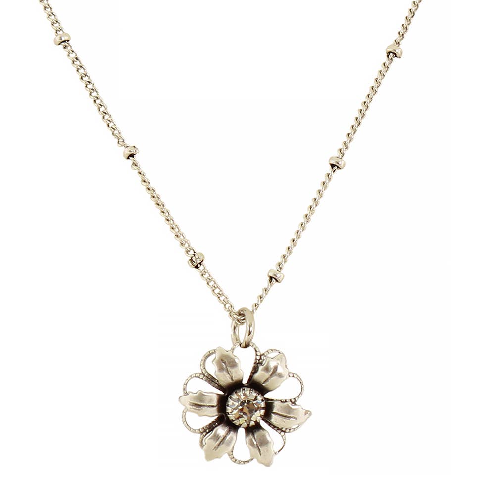 A silver-tone flower pendant necklace on a delicate chain, featuring a central clear gemstone surrounded by textured petals, set against a plain white background.