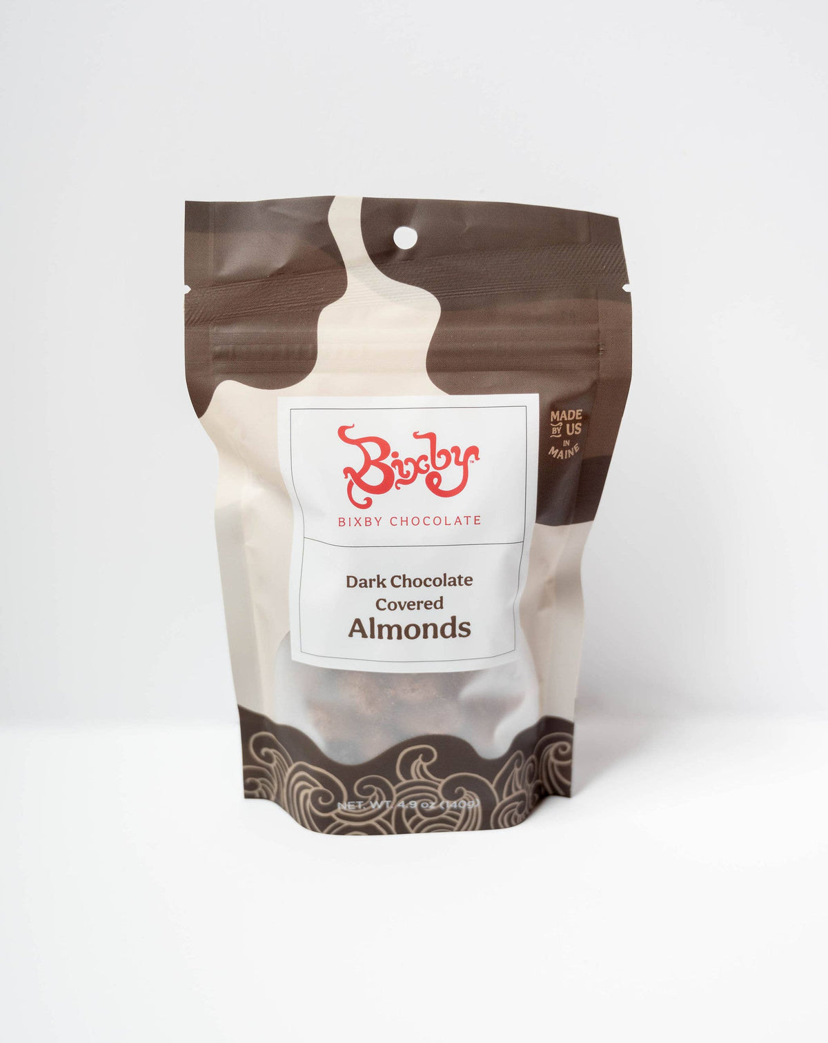 A stand-up pouch of BiboBo Brandy Chocolate Dark Chocolate Covered Almonds, featuring a brown and beige chocolate splash design with a white label and red brand logo, set against a plain white background.