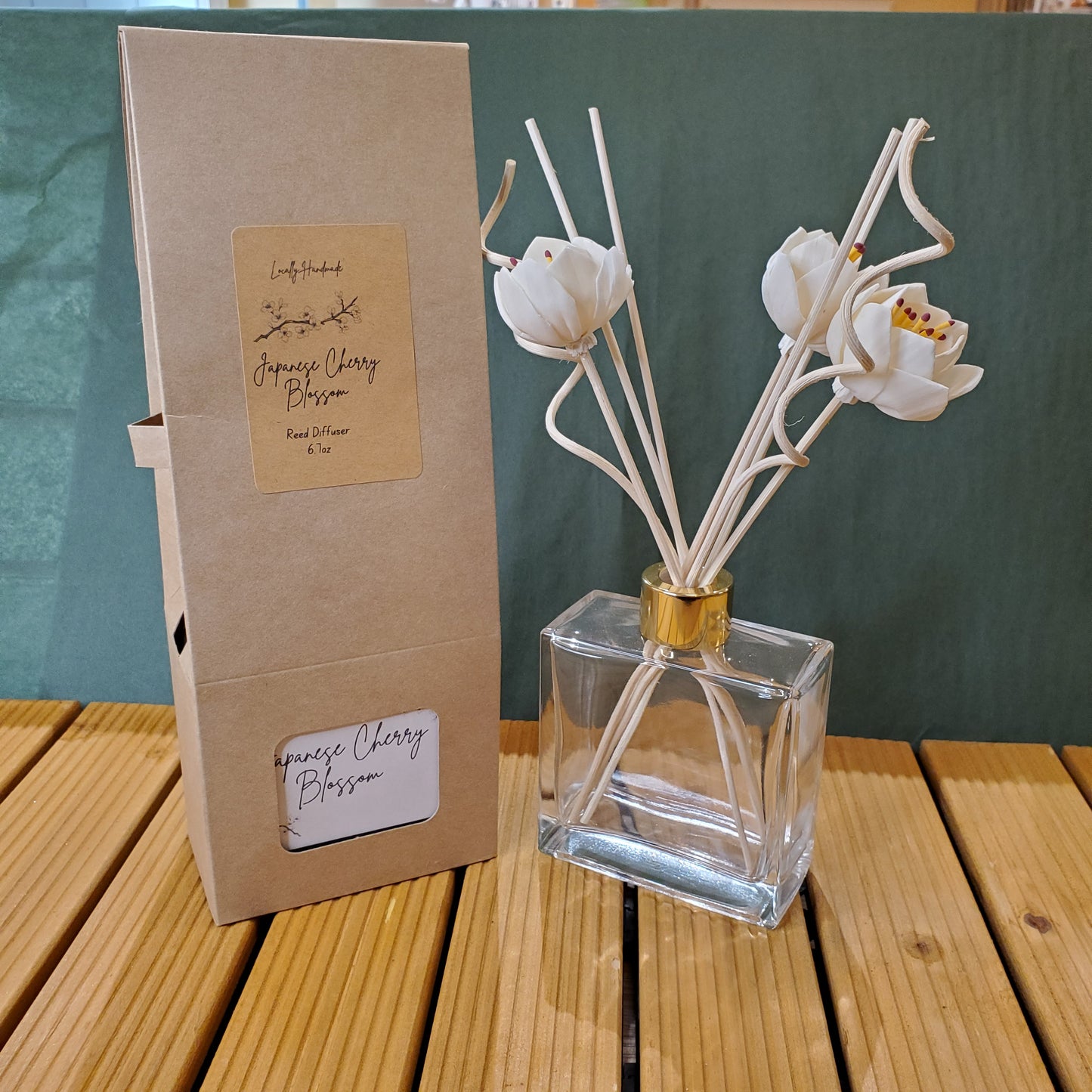 Decorative diffuser with white flowers on a green surface