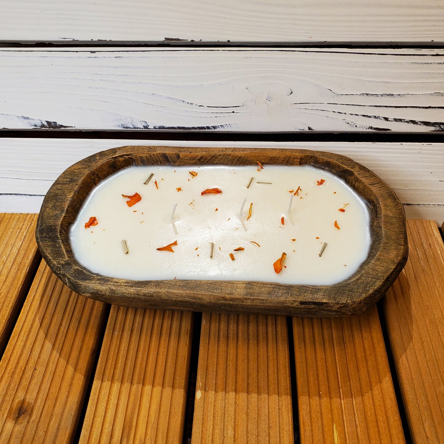 Candle in a wooden holder with decorative elements on a wooden surface