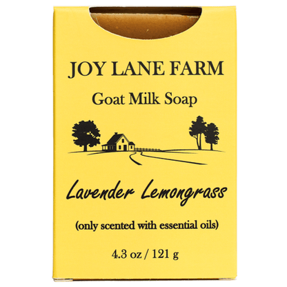 A yellow rectangular box of Joy Lane Farm Goat Milk Soap, specifically the Lavender Lemongrass scent. The box features black text and a simple black line drawing of a farm scene with trees and a house.