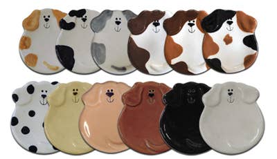 A set of ceramic dog-shaped plates shown in multiple colors and patterns, arranged in two rows against a plain white background.