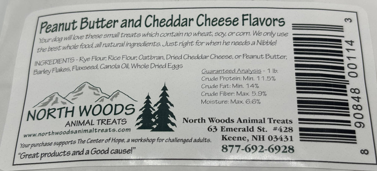 Close-up of a North Woods Animal Treats label showing Peanut Butter and Cheddar Cheese Flavors, with ingredients, guaranteed analysis, address, phone number, and a barcode.