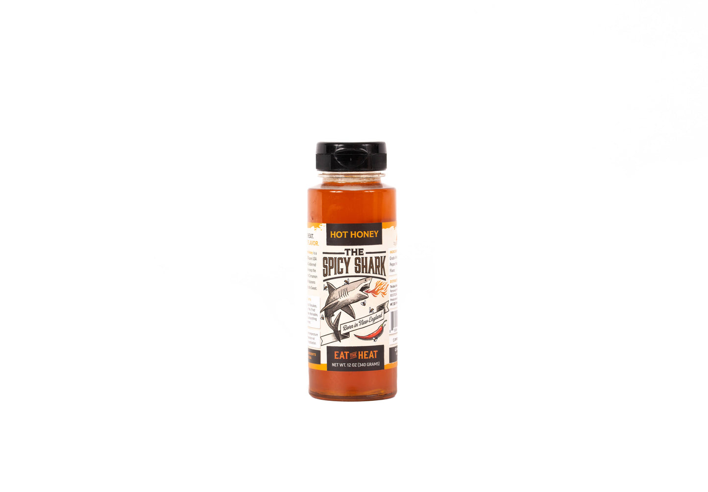 A bottle of 'The Spicy Shark' hot sauce by Hot Honey, featuring a black cap and a label with a shark illustration, set against a plain white background.