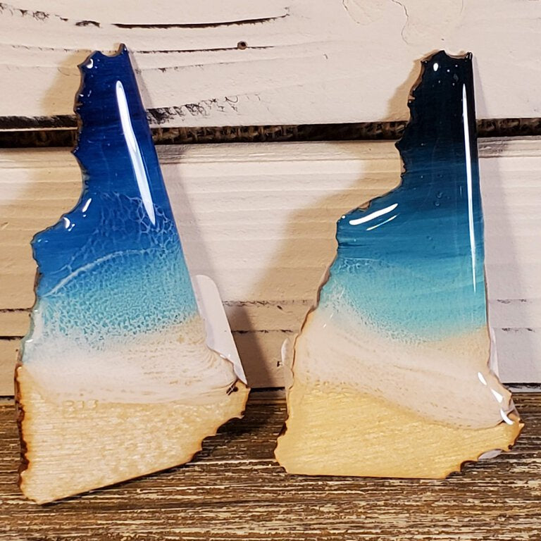 Two wooden bookends with a gradient blue to white design on a wooden surface.