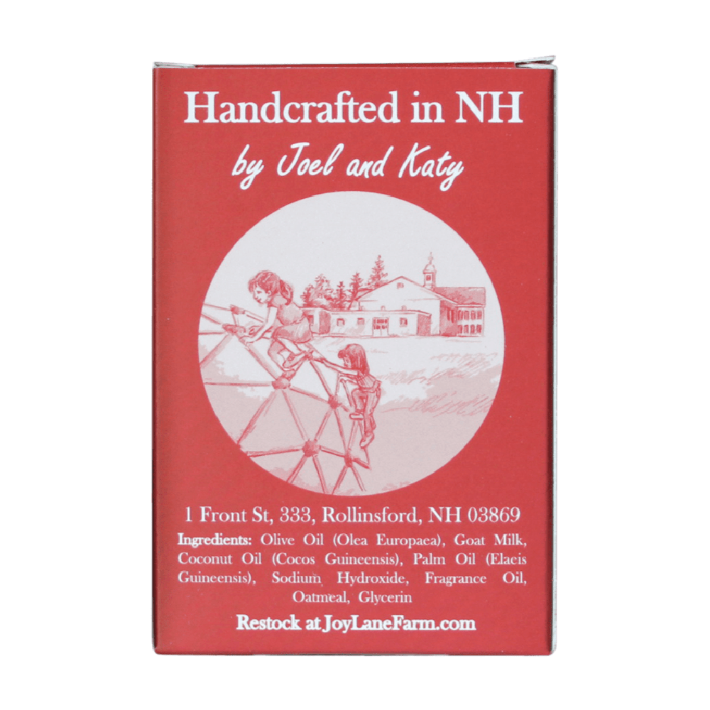 A red rectangular product box with white text reading 'Handcrafted in NH by Joel and Katy' and a circular illustration of children playing outdoors near a house. Additional white text includes an address, ingredients, and 'Restock at JoyLaneFarm.