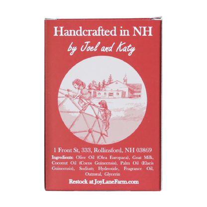 A red rectangular product box with white text reading 'Handcrafted in NH by Joel and Katy' and a circular illustration of children playing outdoors near a house. Additional white text includes an address, ingredients, and 'Restock at JoyLaneFarm.