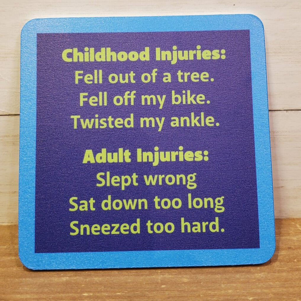 A square coaster with blue edges and a white center, featuring text that humorously lists childhood and adult injuries.