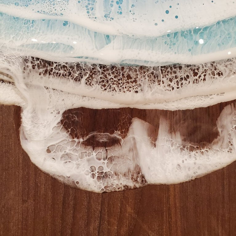 A medium-sized walnut wood serving board with a rustic finish, displayed on a wooden surface.