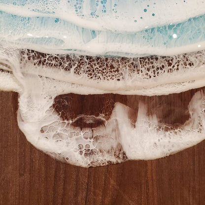 A medium-sized walnut wood serving board with a rustic finish, displayed on a wooden surface.