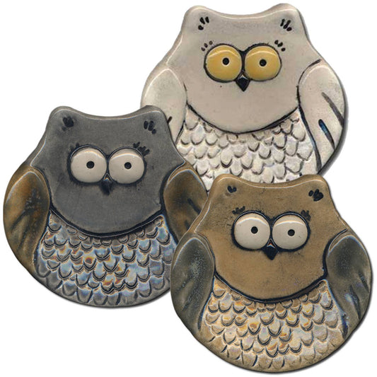 Three ceramic owl coasters with different color patterns on a white background