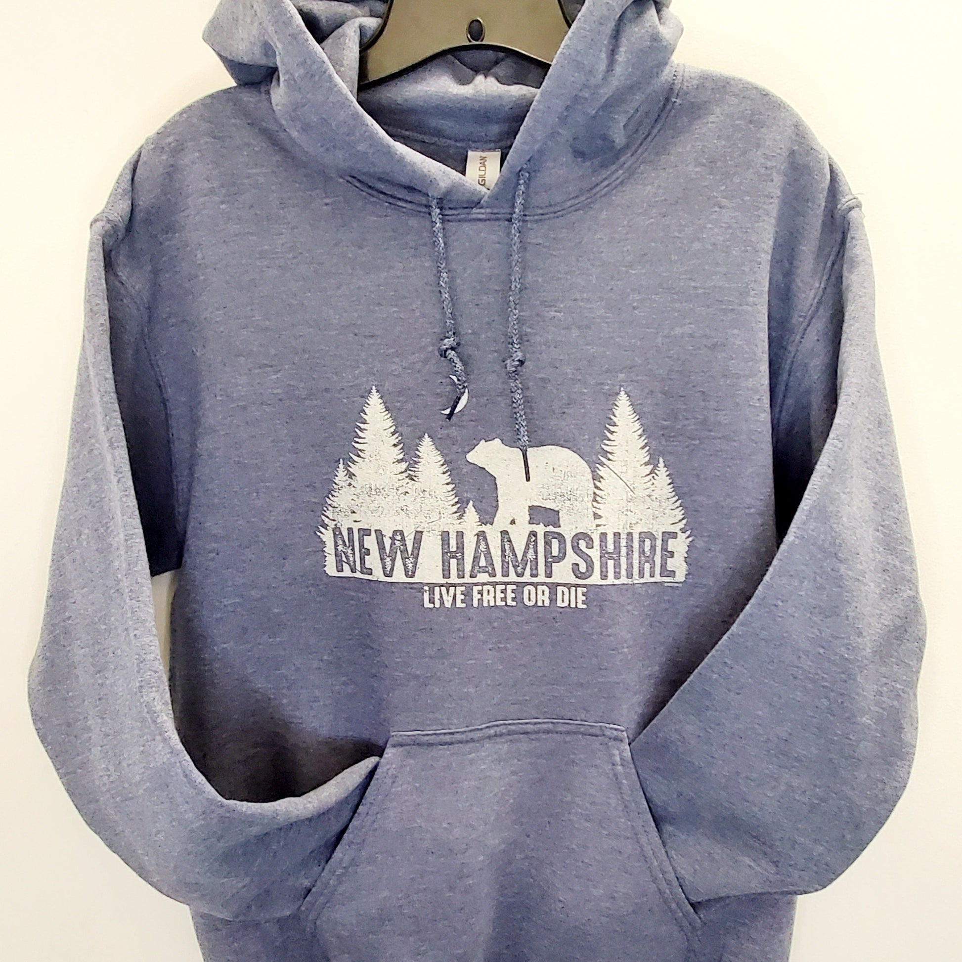 Blue hoodie with New Hampshire design on a beige background