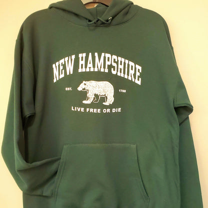 Green hoodie with 'New Hampshire' and bear graphic on a beige background