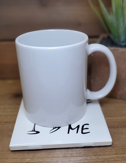 White mug on a coaster with 'I ❤️ ME' text on a wooden surface.