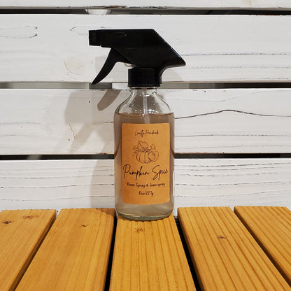 Bottle of pumpkin spice spray on a wooden surface with a white background