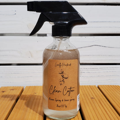 Clear spray bottle with brown label on a wooden surface