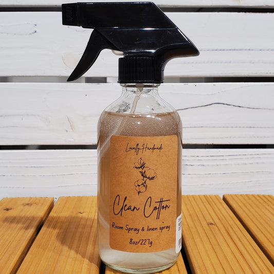 Clear spray bottle with brown label on a wooden surface