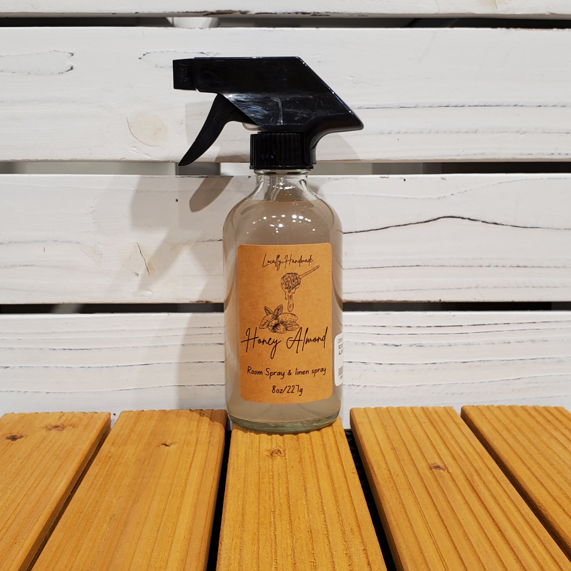 Bottle of honey almond spray on a wooden surface