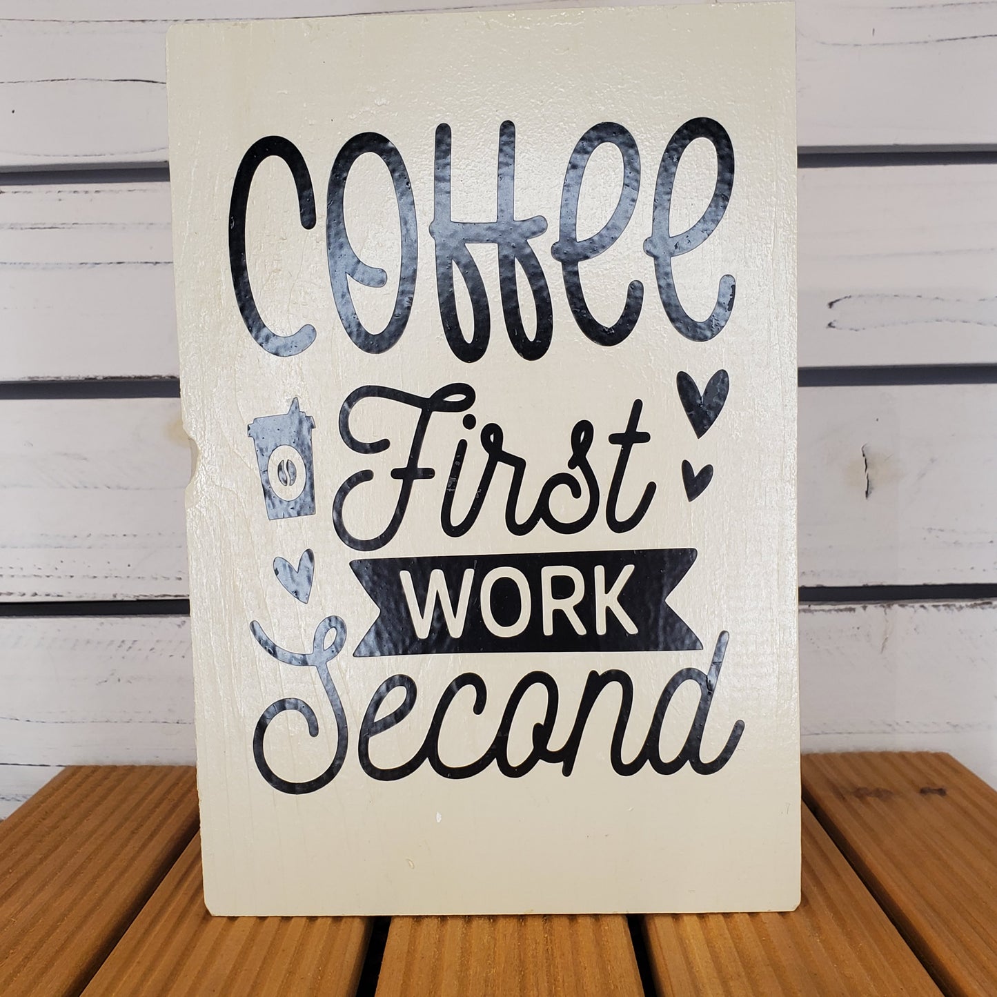 Wooden sign with text 'Coffee First, Work Second' on a wooden background