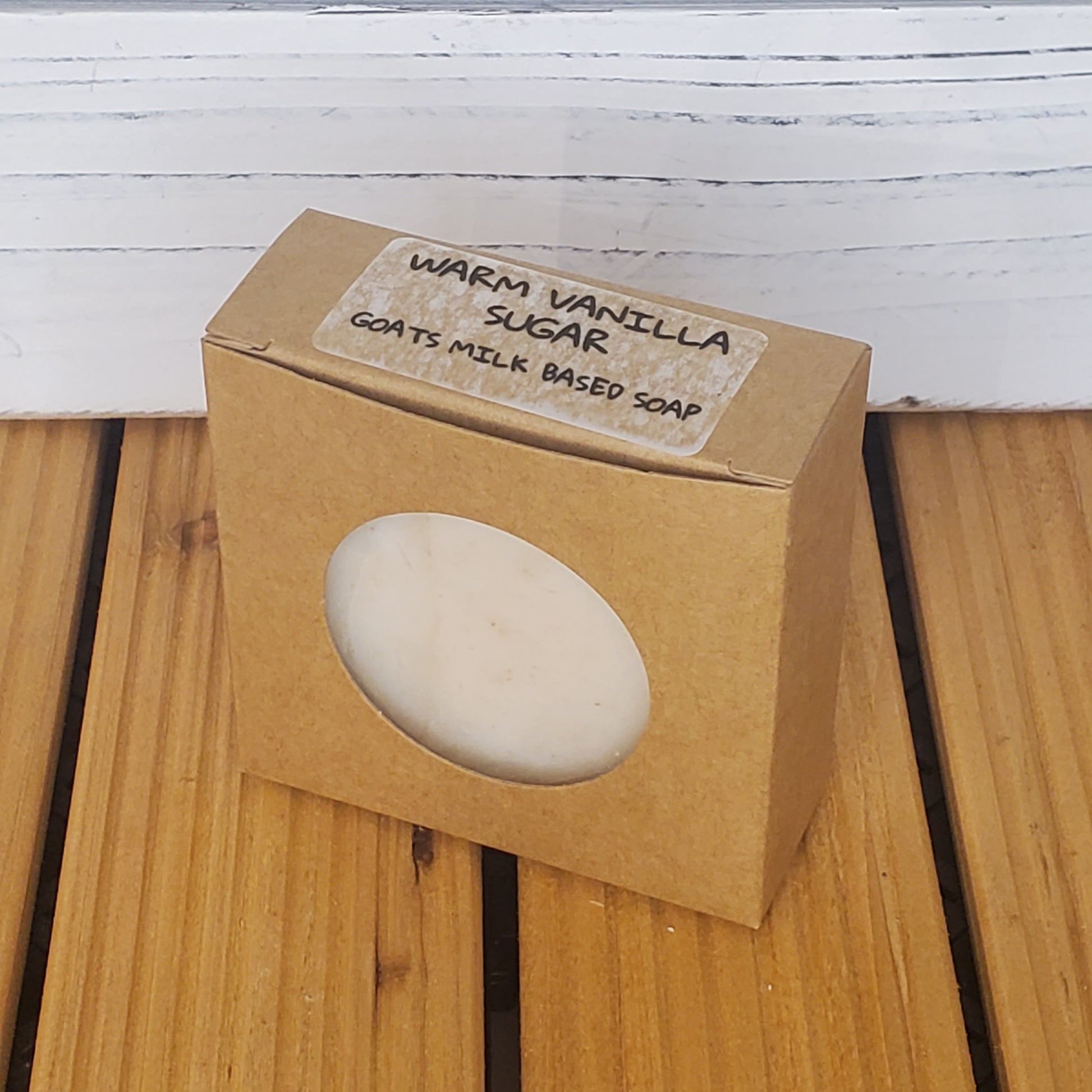 Bar of soap in a brown cardboard box on a wooden surface