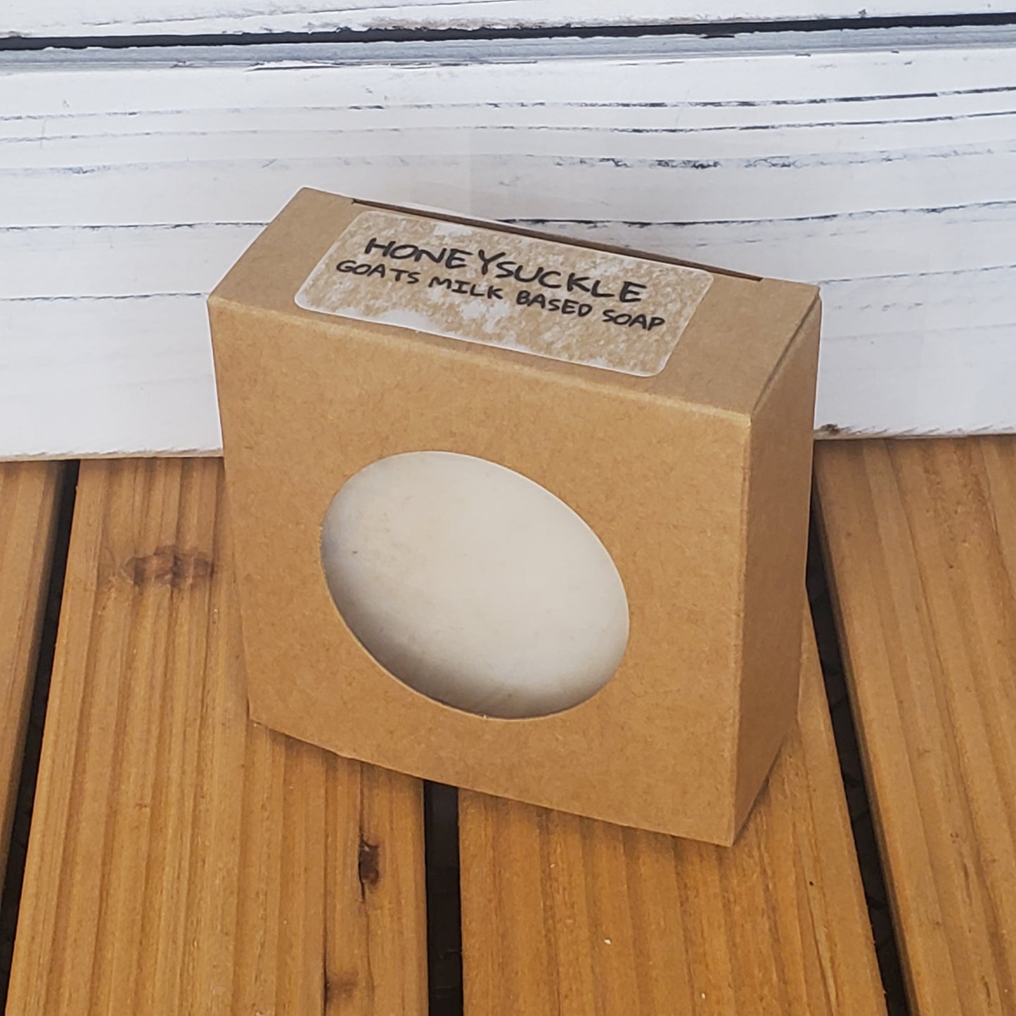 Bar of soap in a brown cardboard box on a wooden surface