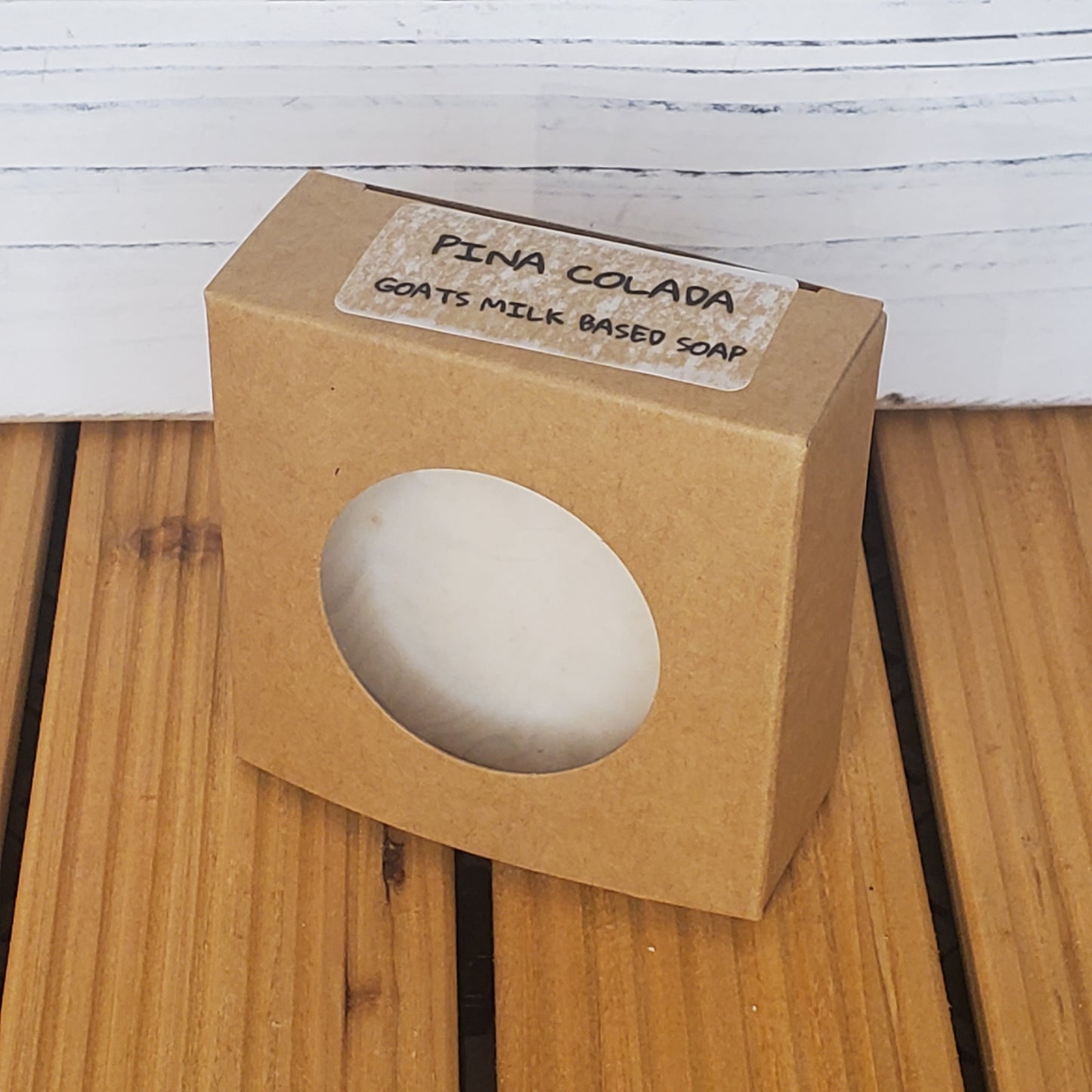Goats' milk-based soap in a brown box on a wooden surface