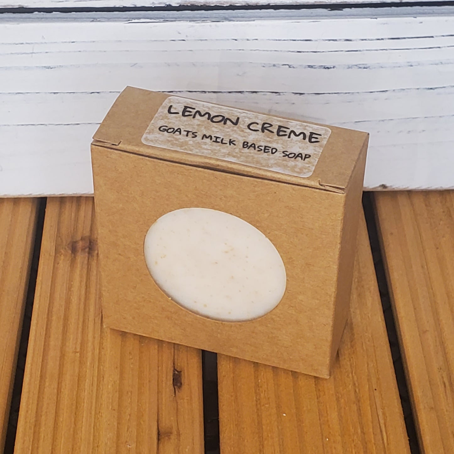 Bar of soap in a brown box with 'Lemon Crème' label on a wooden surface.