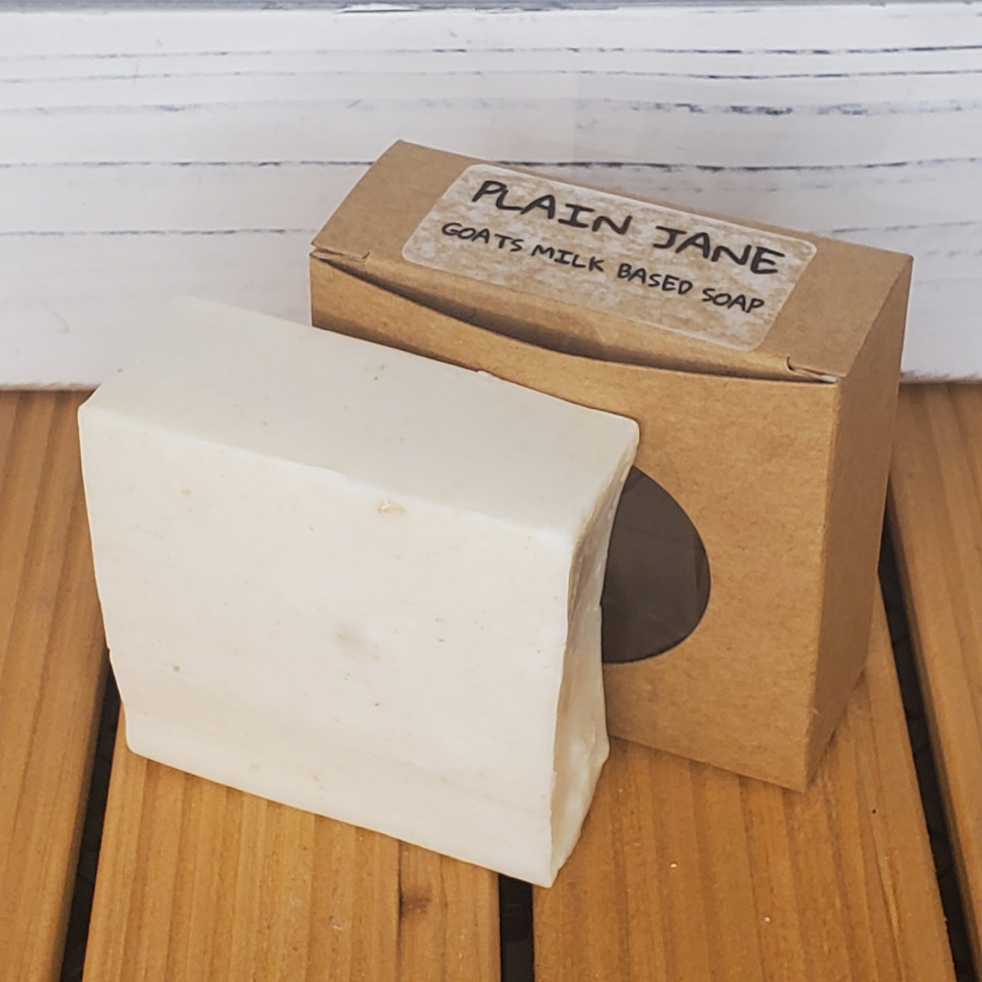 Bar of soap with a cardboard box labeled 'Plain Jane' on a wooden surface.