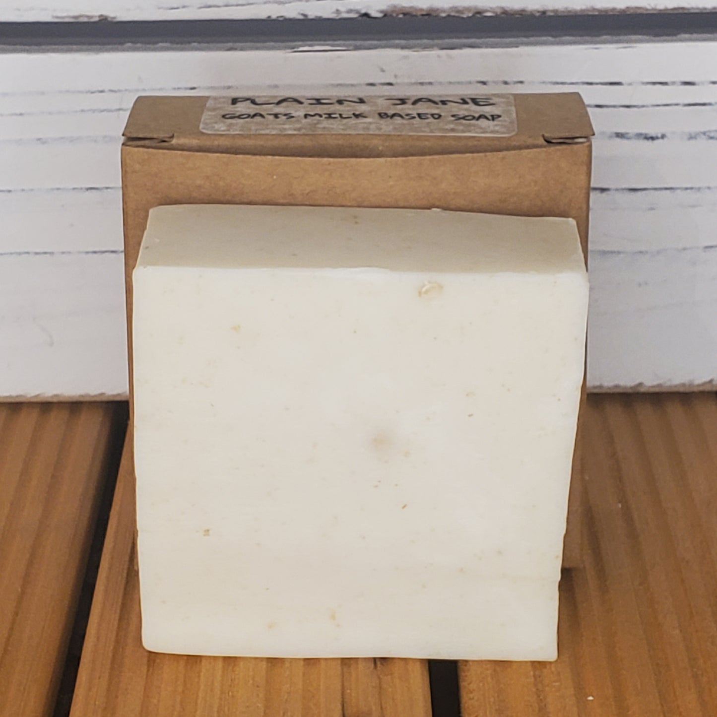 Bar of soap on a wooden block with a label in the background
