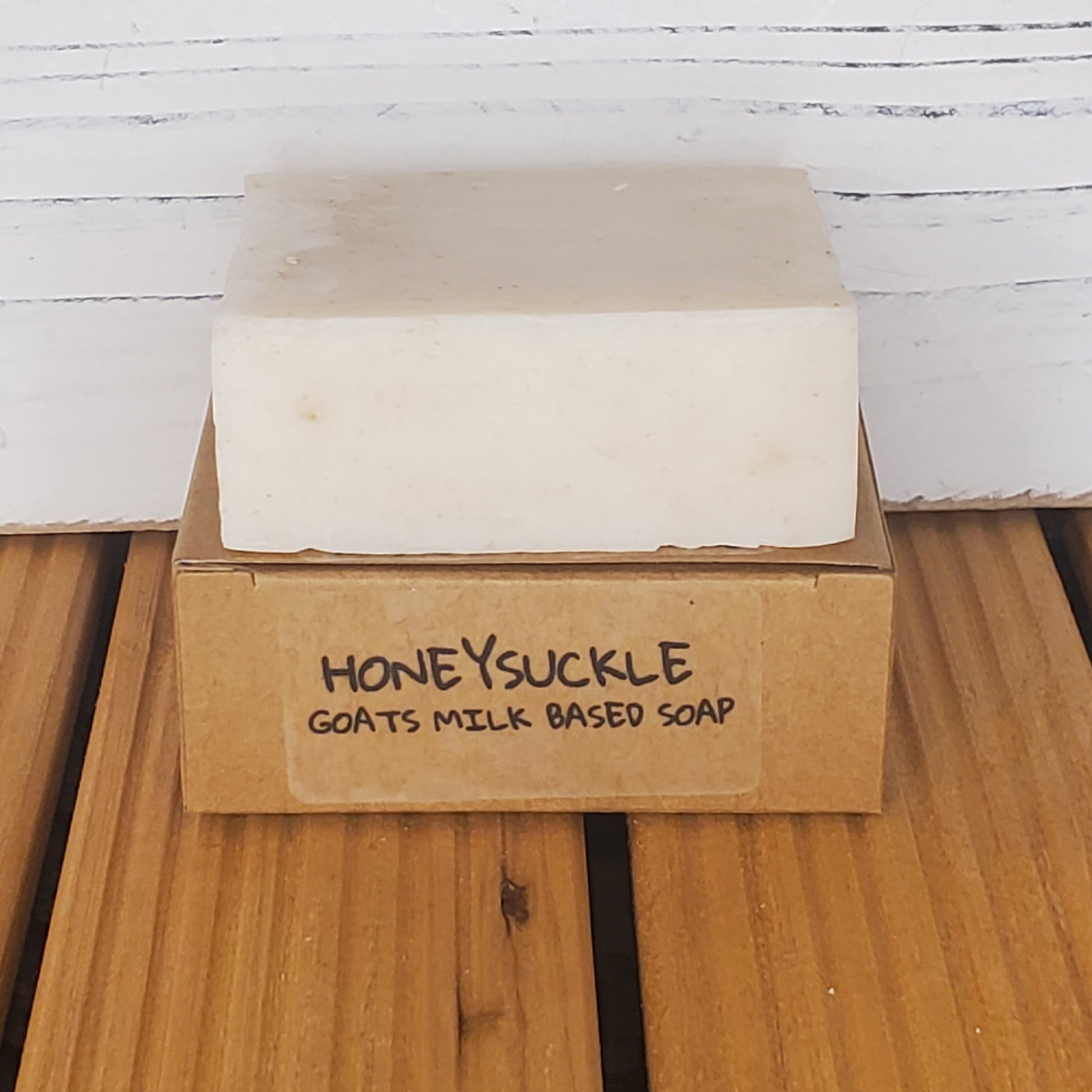 Bar of soap with a 'Honeysuckle' label on a wooden surface