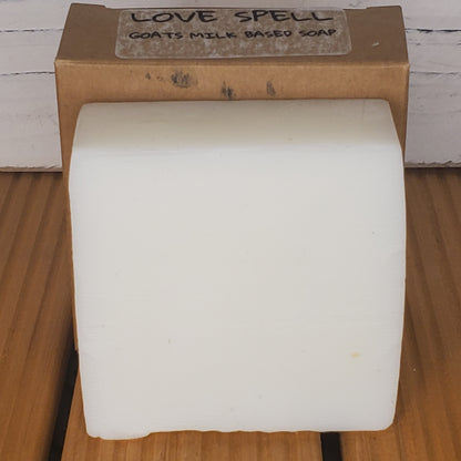 Bar of soap on a wooden block with 'Love Spell' label