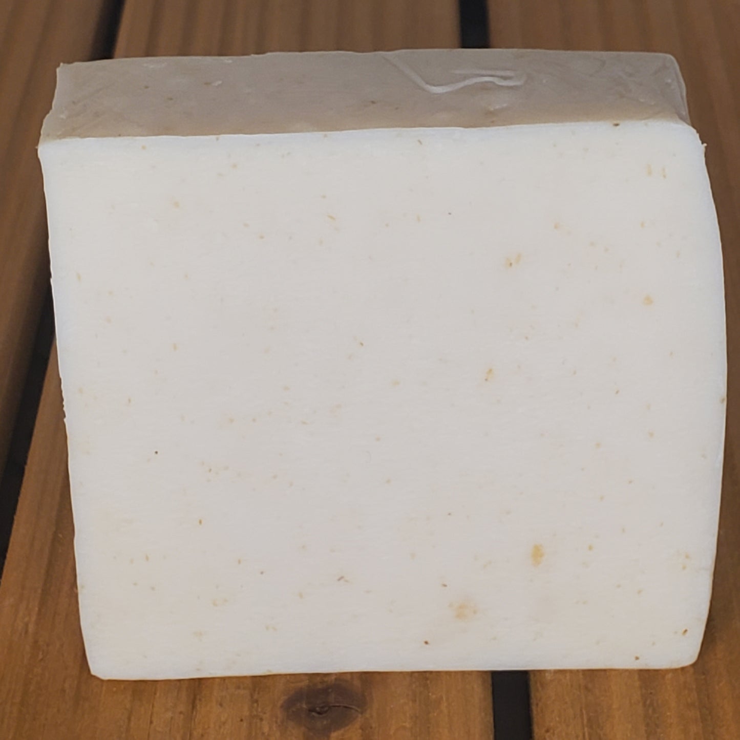 Block of white cheese on a wooden surface