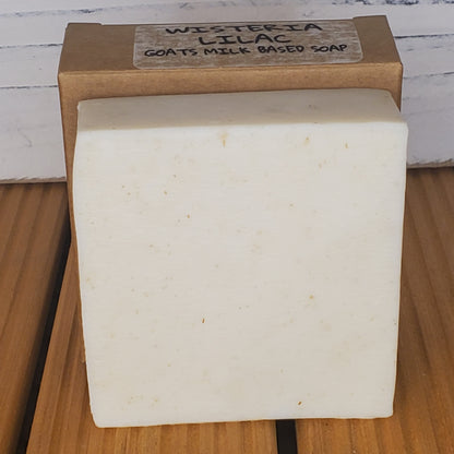 Bar of soap with a wooden box labeled 'Wisteria Lilac' on a wooden surface.