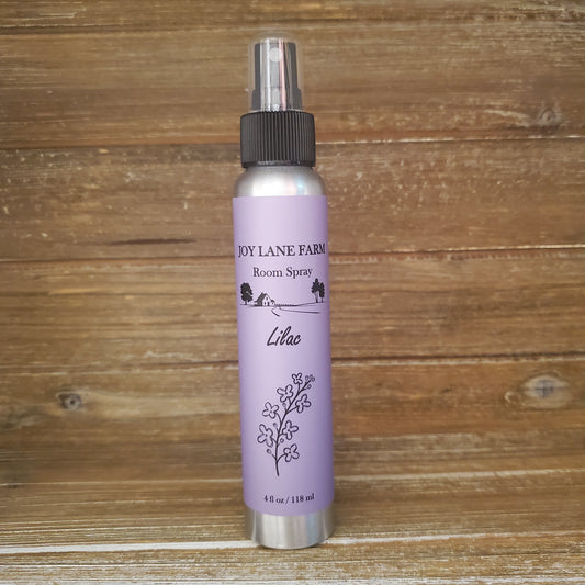 Purple canister with black nozzle on a wooden surface
