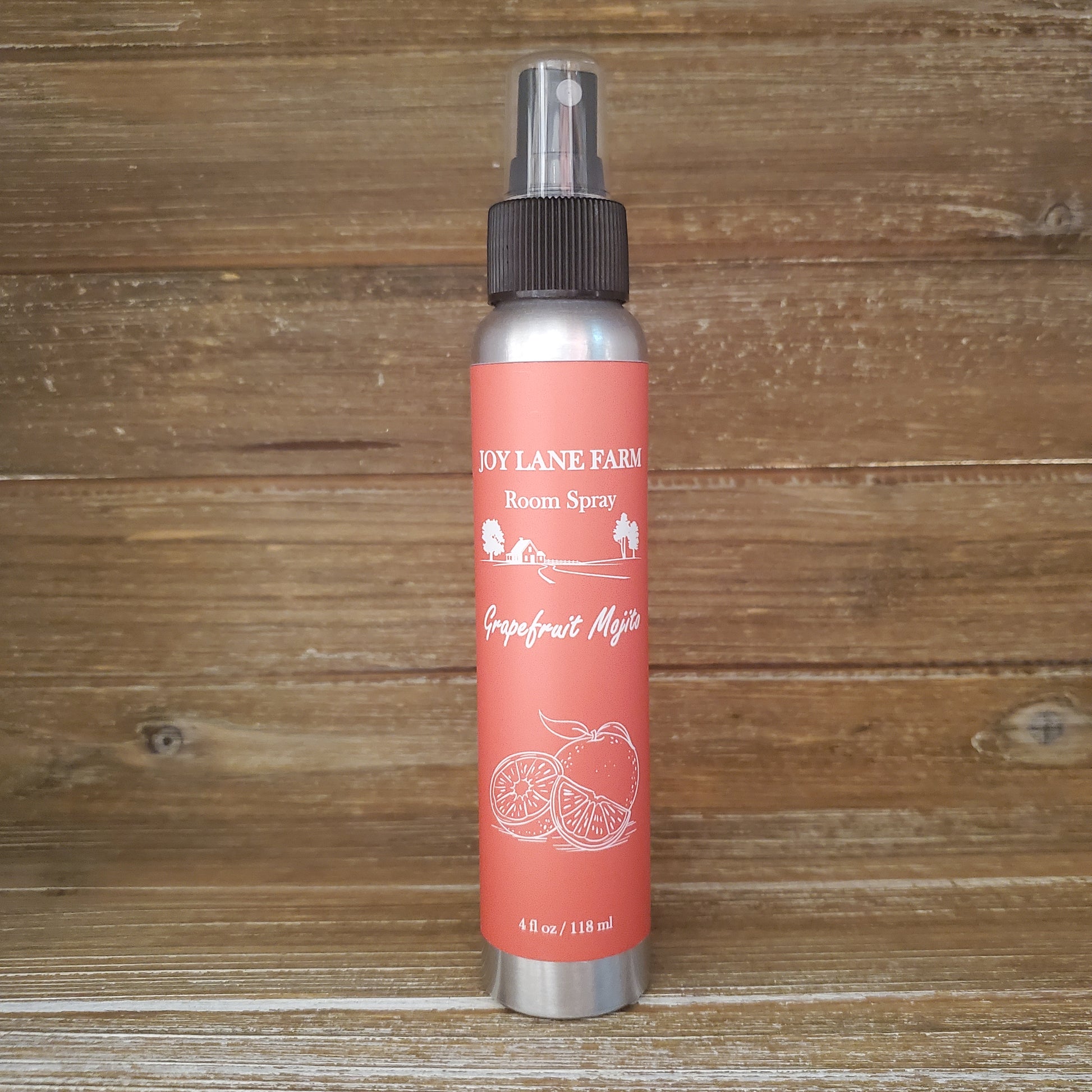 Red spray bottle with silver nozzle on a wooden surface