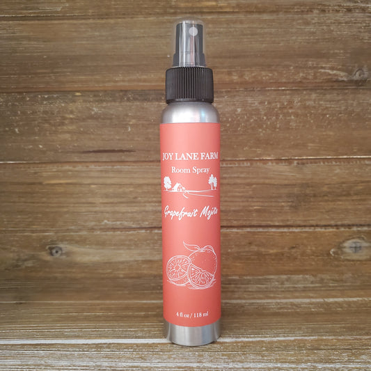 Red spray bottle with silver nozzle on a wooden surface