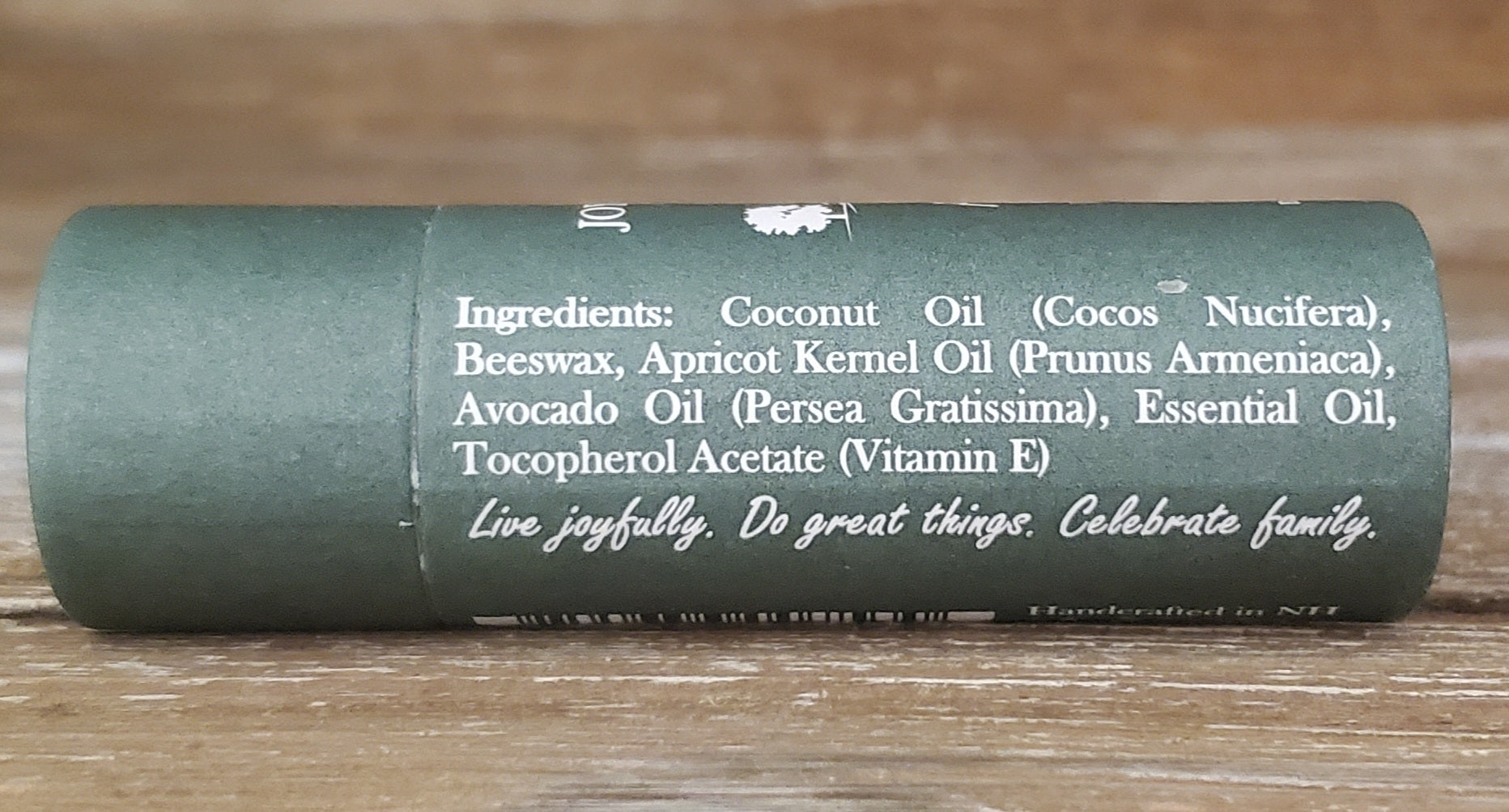 Green cylindrical container with text on a wooden surface