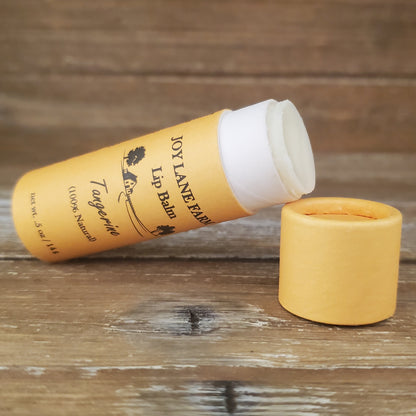 Lip balm with yellow container and white cap on a wooden surface