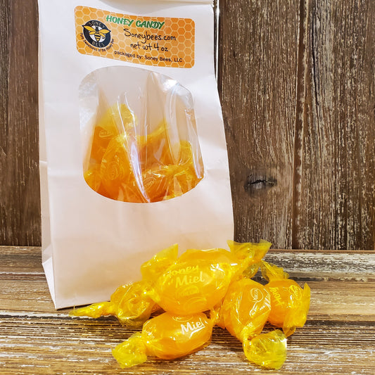 Honeycomb candy in a clear bag with a label on a wooden surface