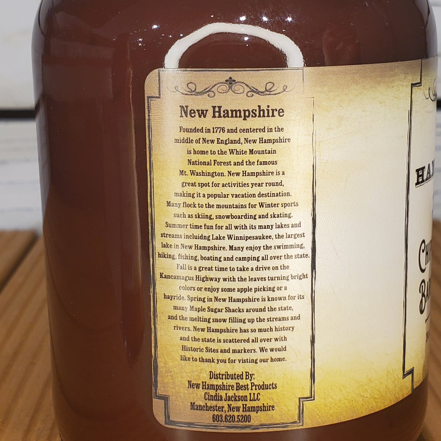 Bottle of New Hampshire maple syrup with a label on a wooden surface