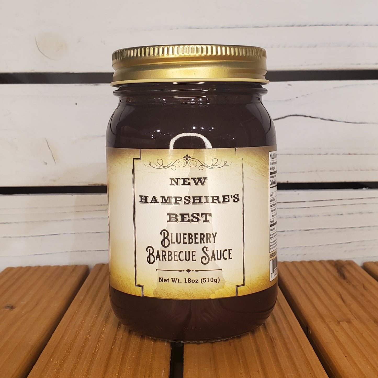 Jar of New Hampshire's Best Blueberry Barbecue Sauce on a wooden surface with a white background