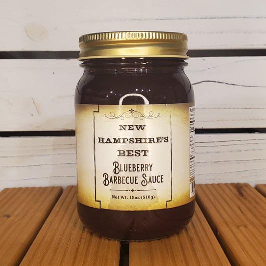 Jar of New Hampshire's Best Blueberry Barbecue Sauce on a wooden surface with a white background