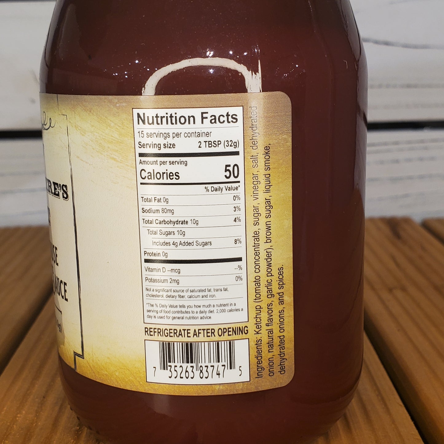 Bottle of sauce with nutrition facts label on a wooden surface